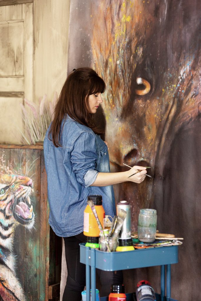 L'artiste peintre Sandrot dans son atelier peignant un aigle 